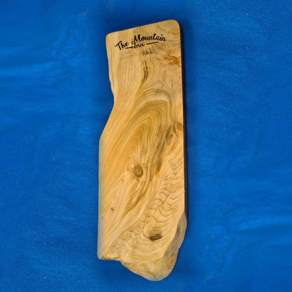 Close-up of laser engraved branding on live edge cedar charcuterie board – Moon Groves Devon UK