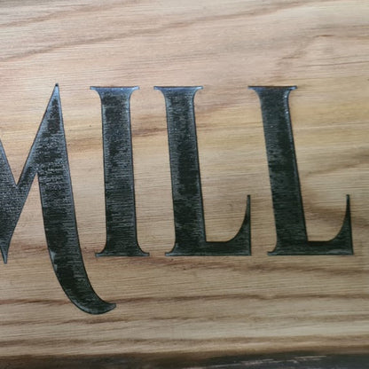 Close-up of natural timber grain and engraving on wooden gate sign – Moon Groves Devon UK