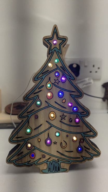 Personalised beech ply baubles hanging on Christmas tree – laser engraved by Moon Groves Devon