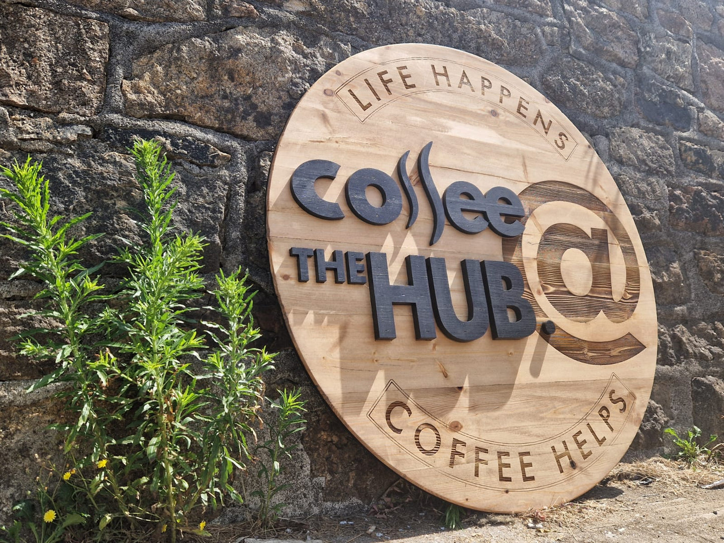 Bespoke 3D wooden round sign installed on café exterior wall – custom commercial signage by Moon Groves, handmade in Devon UK